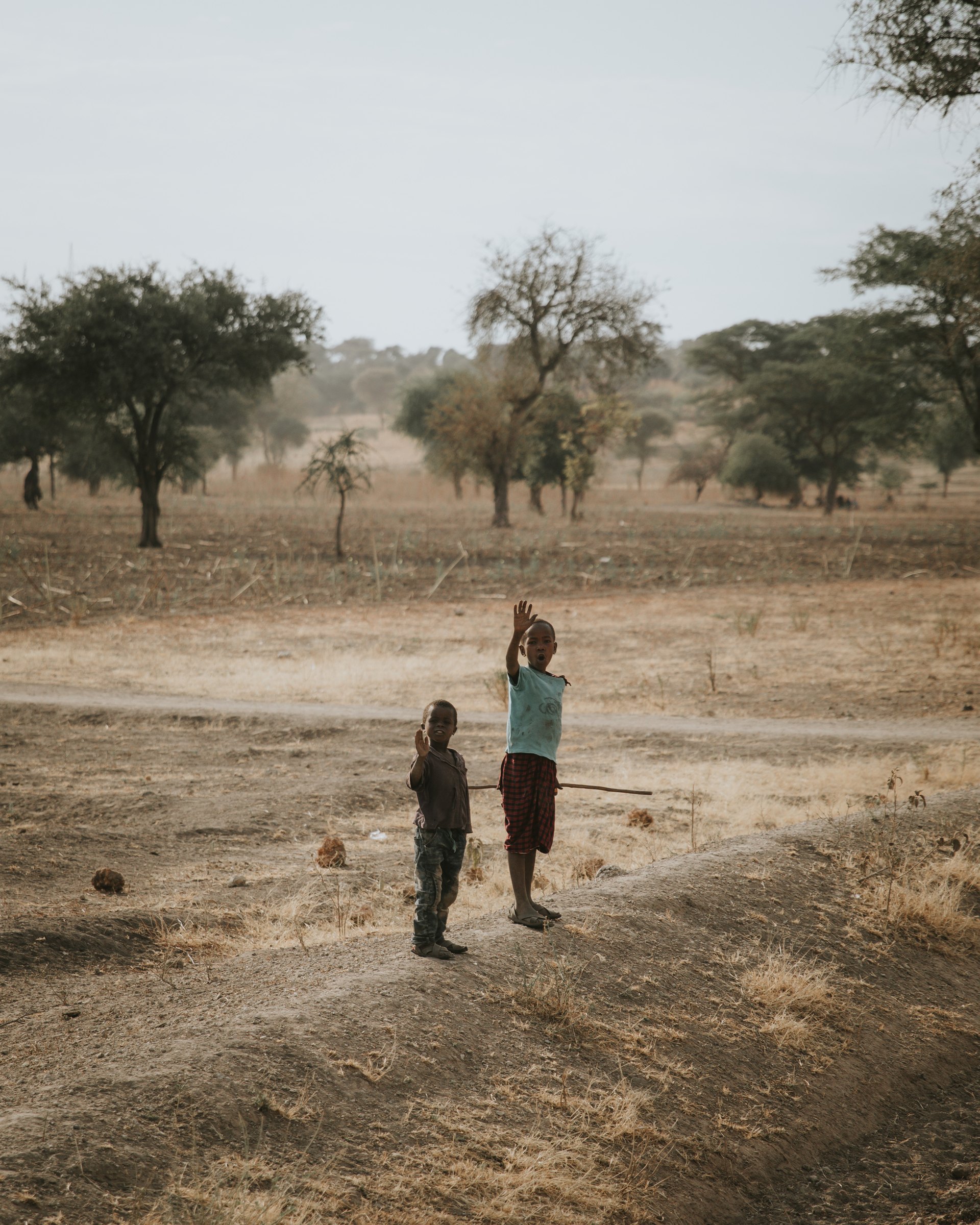 Two children waving in Africa