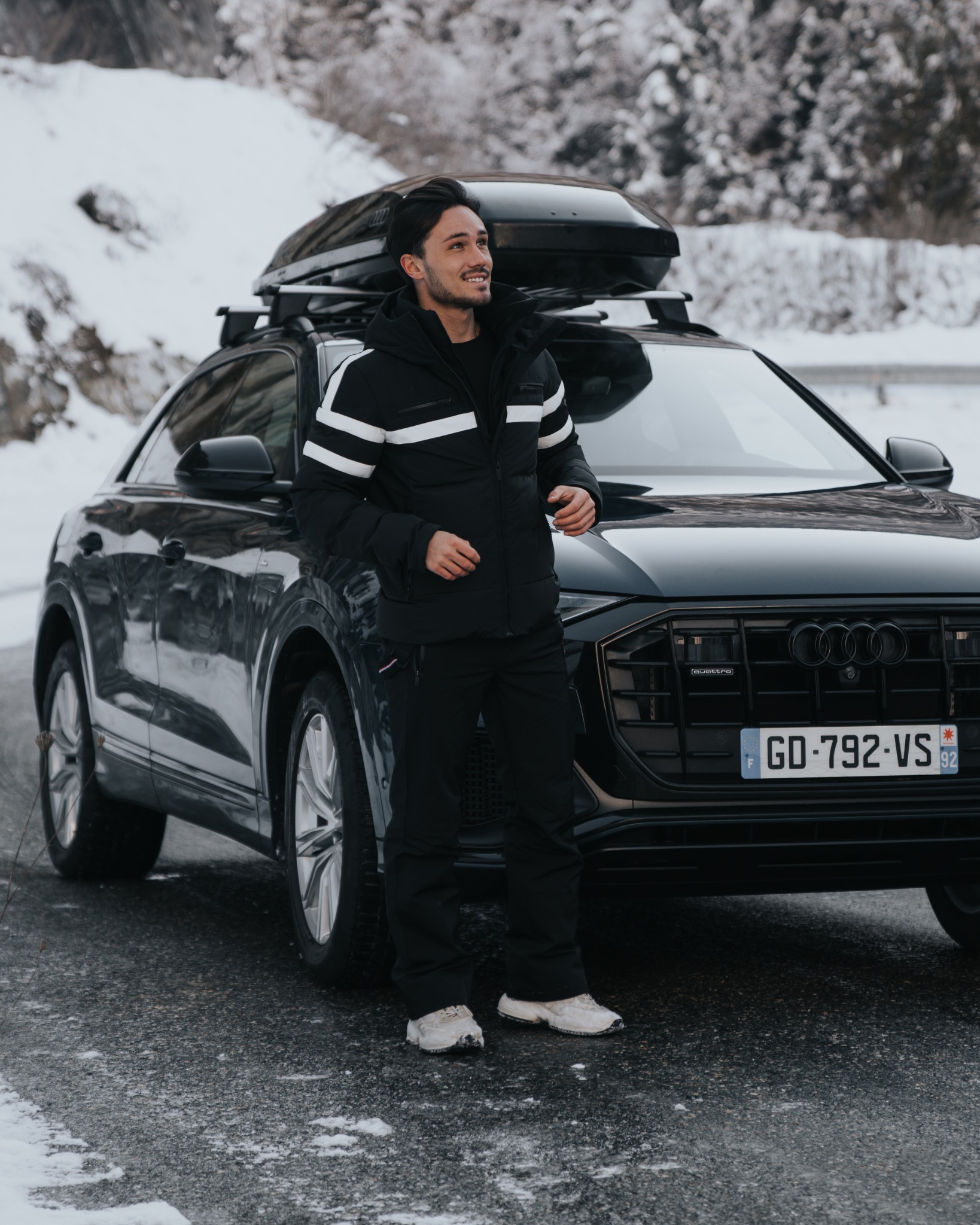 Enzo Carini standing beside an Audi in a snowy setting