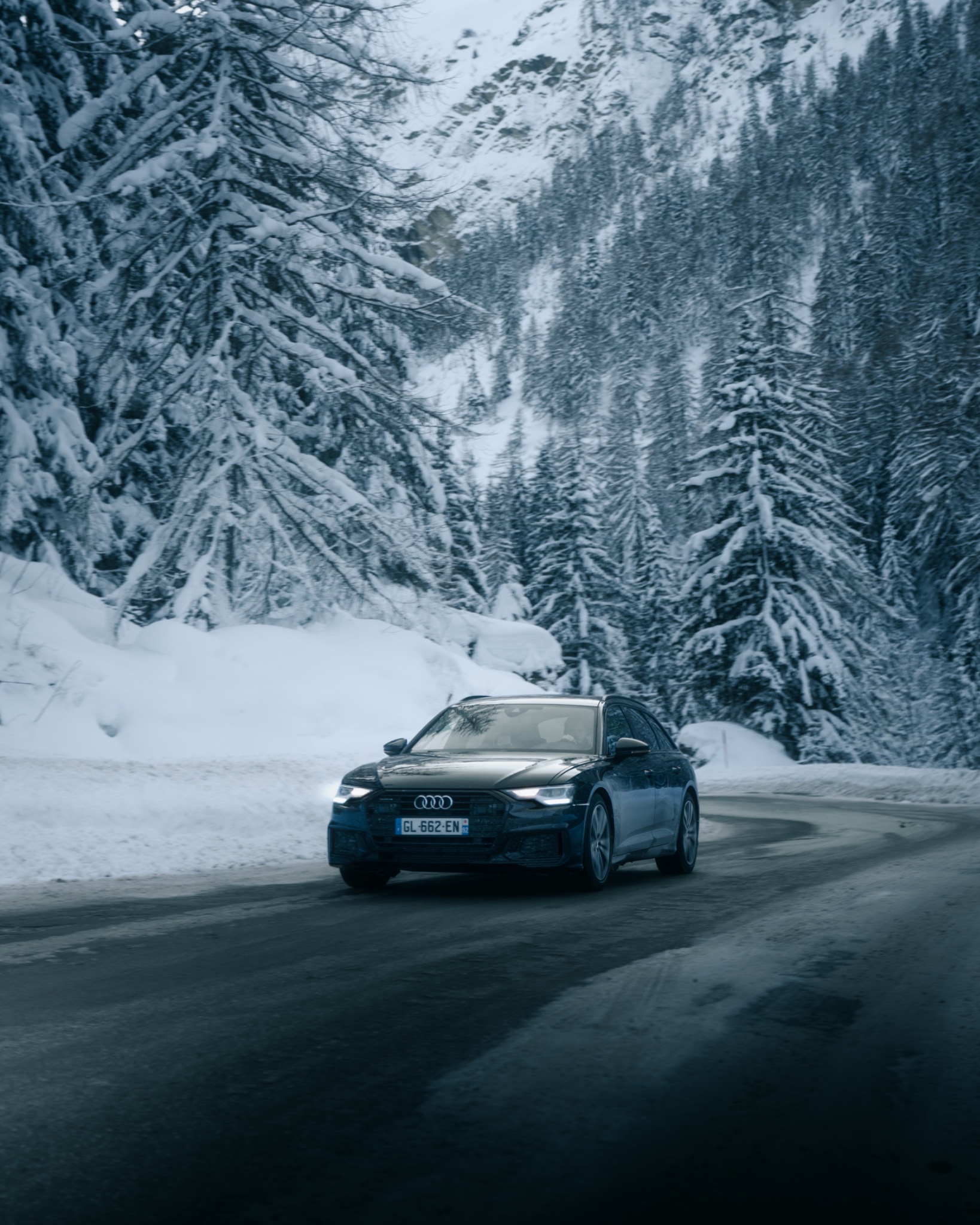 Audi driving through a snowy alpine road