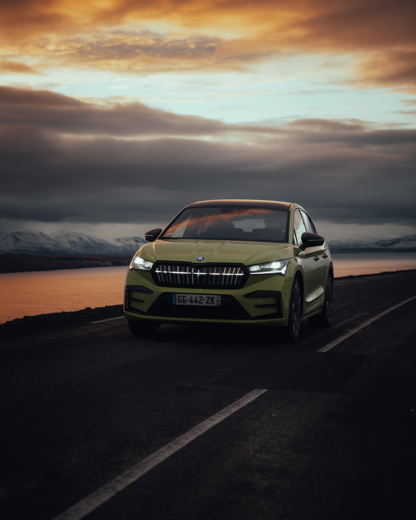 Green Skoda driving at sunset